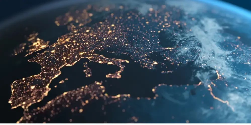  Aerial view of Europe at night with city lights illuminating the landscape, symbolizing connectivity, economic activity, and globalization. 