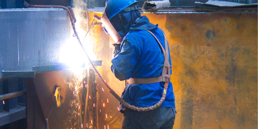  metal welding in blue jump suit 