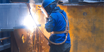 metal welding in blue jump suit