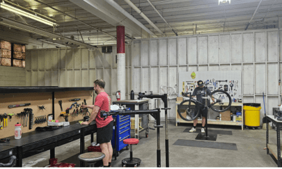 Two technicians assembling and repairing bicycles in a workshop.