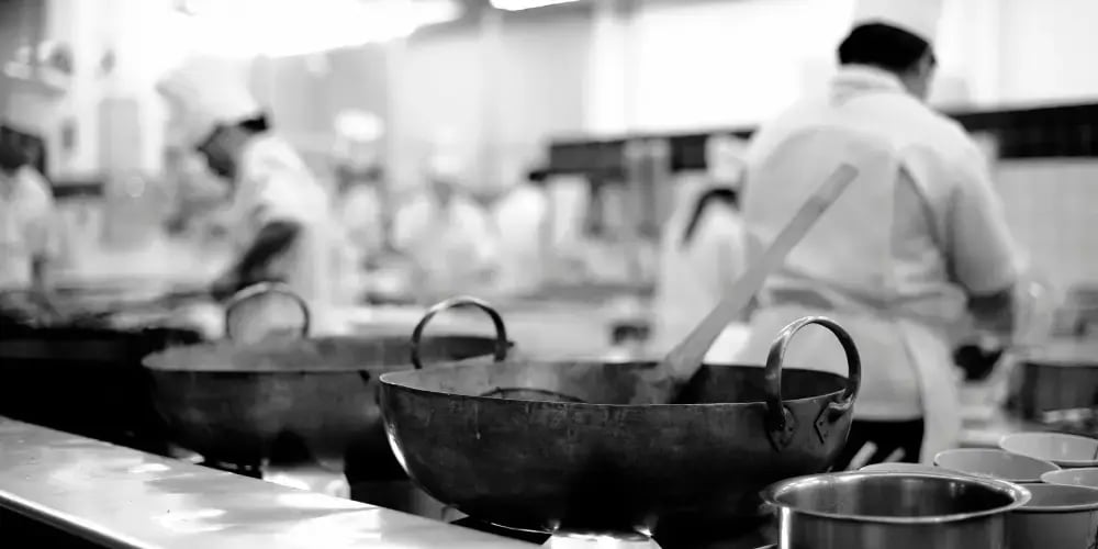  A chef skillfully tossing ingredients in a wok over high flames in a bustling restaurant kitchen, with steam and vibrant colors from vegetables filling the air, capturing the intensity and focus of professional cooking. 