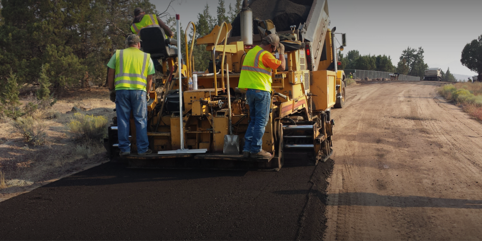 construction workers paving a road 