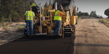 construction workers paving a road