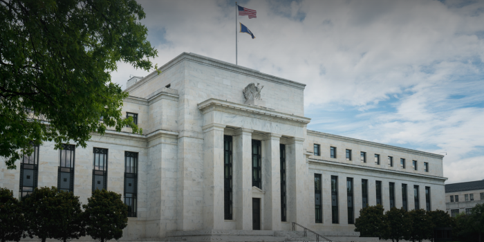 The Federal Reserve building in Washington, D.C. with flags flying on top.