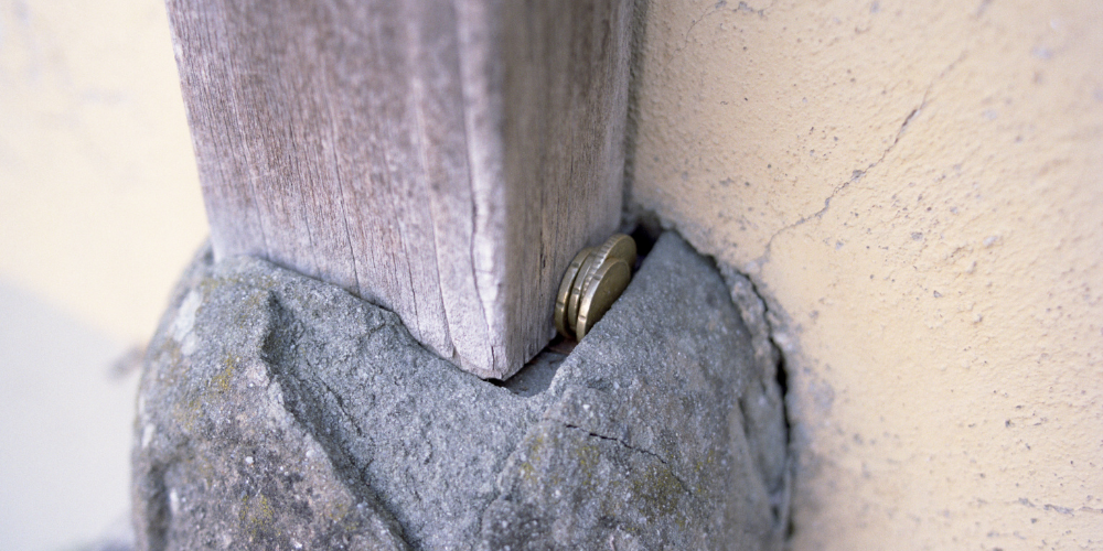 coins filling a gap in concrete